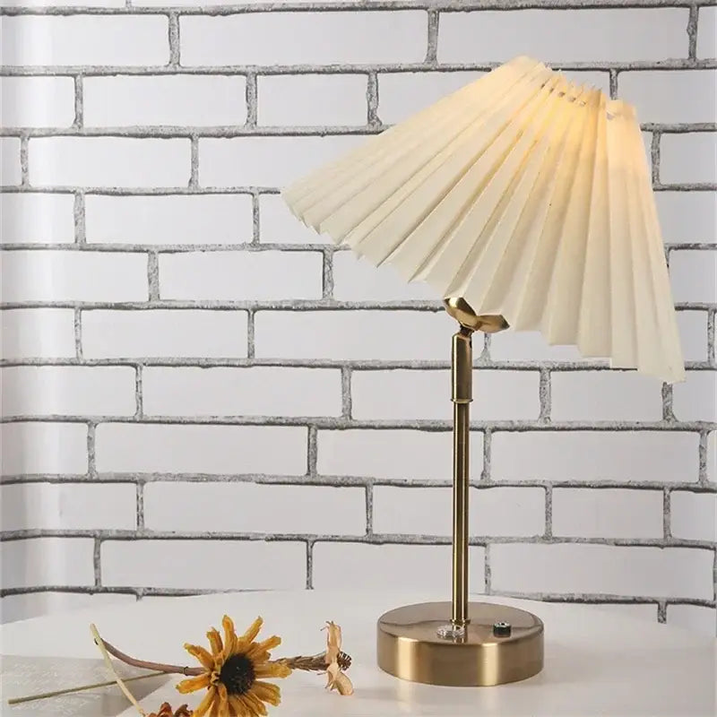 Cream-colored pleated table lamp with brass-finished base and adjustable pleated design for decorbites adjustable pleated use