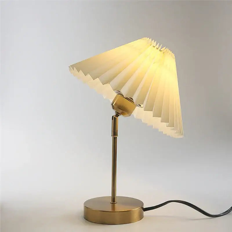 Brass-finished adjustable pleated table lamp with an off-white cream paper shade for bedroom lighting