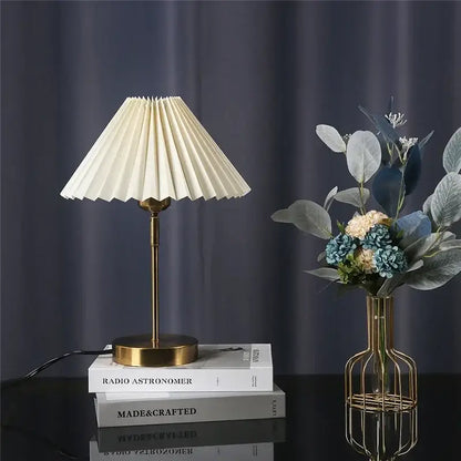 Cream-colored pleated table lamp with brass base and stem decorbites adjustable pleated bedroom light