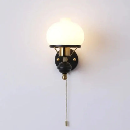 A retro brass and black french wall lamp with frosted glass globe and metal base ideal for bedroom lighting decorbites french wall lamp