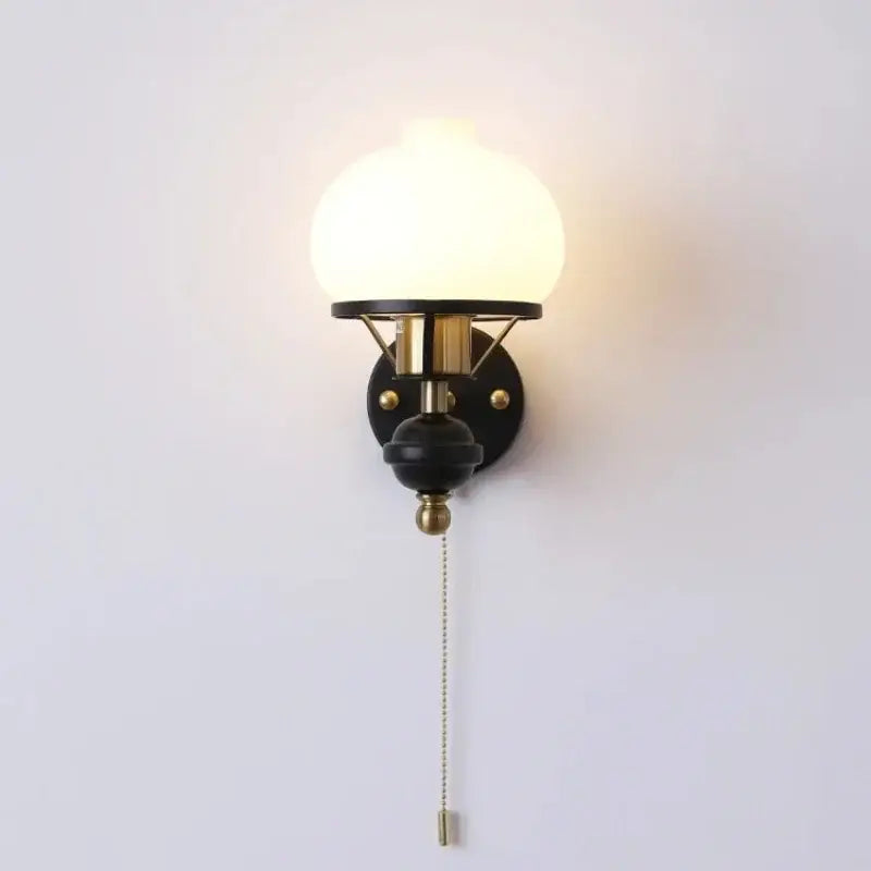 A retro brass and black french wall lamp with frosted glass globe and metal base ideal for bedroom lighting decorbites french wall lamp