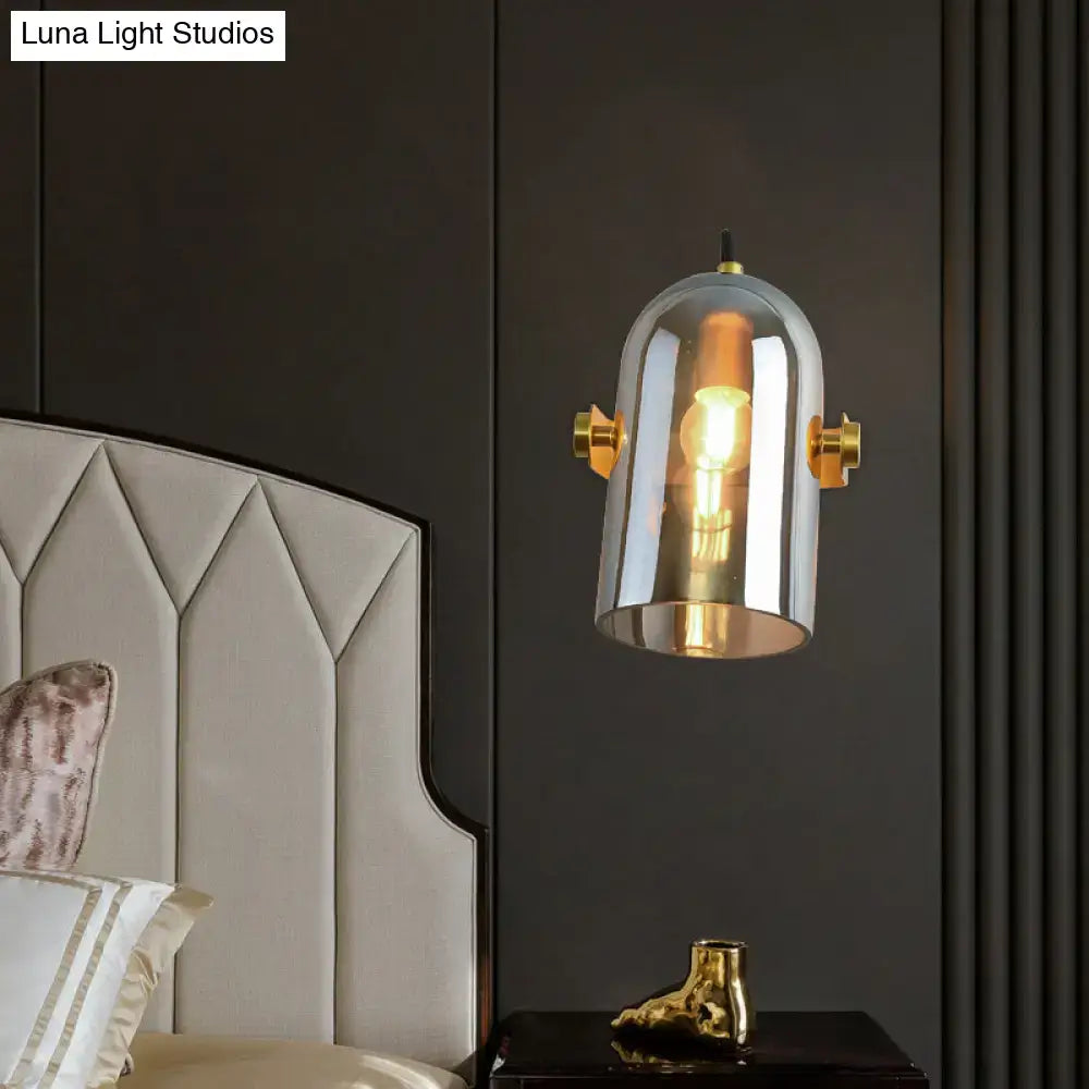 Retro brass cloche sconce light with blue glass and gold-toned accents featuring a clear dome and exposed bulb
