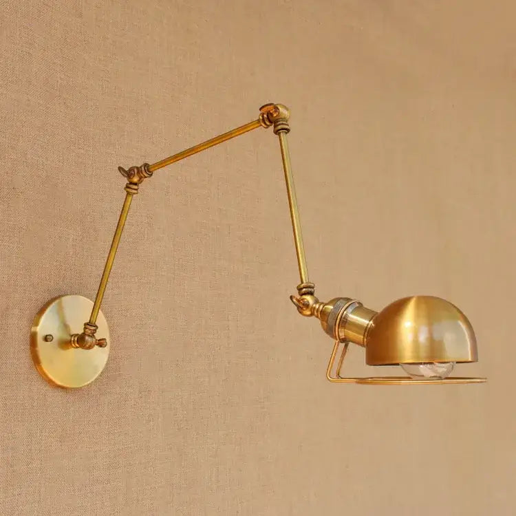 Brass adjustable wall sconce with articulated arms and dome-shaped shade from decorbites golden loft swing collection