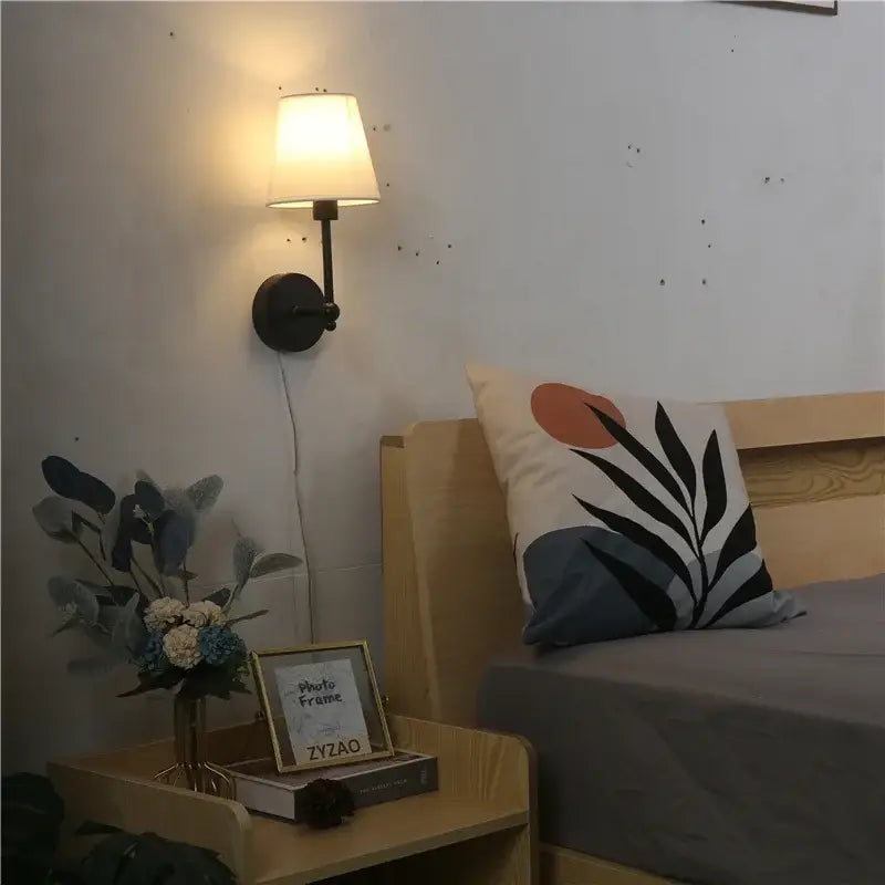 Black wrought iron wall lamp with cream fabric shade featuring a led retro wall design for bedroom use