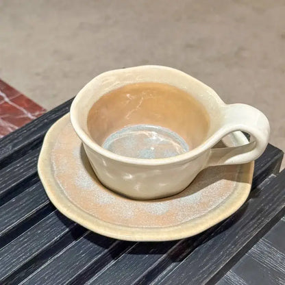 Cream-colored kiln porcelain cup with matching saucer featuring textured glaze and handcrafted decorbites kiln design