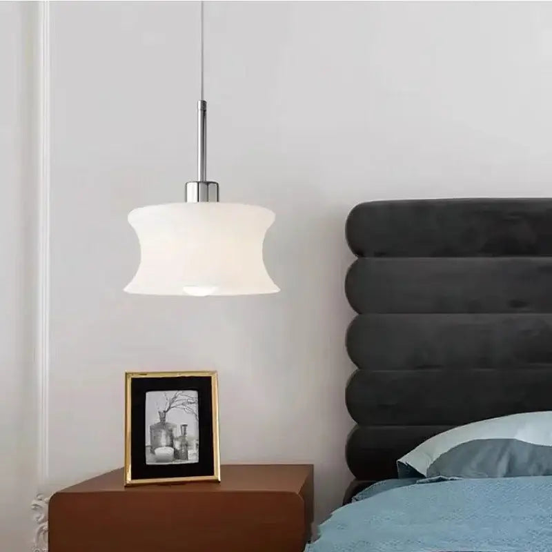 A modern decorbites glass chandelier pendant light with chrome stem and off-white curved glass shade for bedroom decor