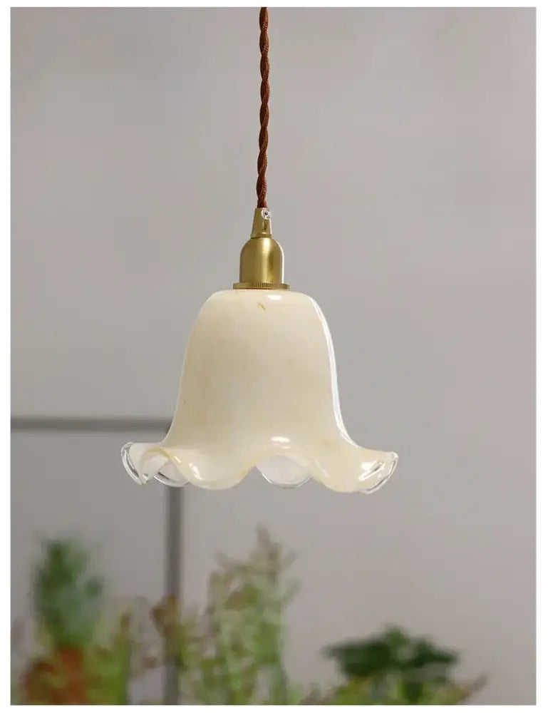 Cream-colored glass led pendant lamp with brass finish and twisted brown cord for kitchen lighting