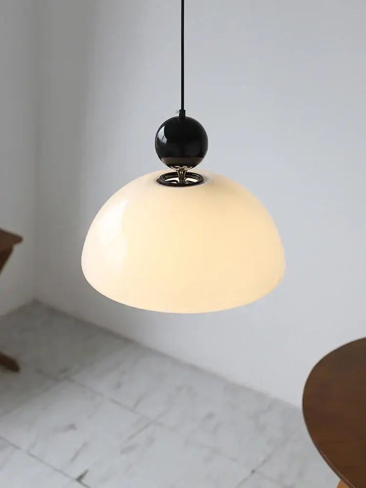 A sleek black spherical pendant light with a cream glass retro opal dome for dining room decorbites cream glass decor