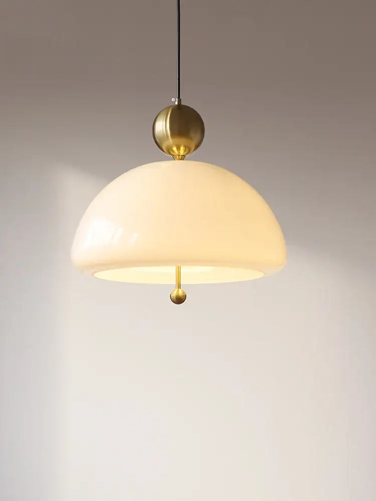 A cream glass retro pendant light with warm opalescent dome and brass accents for dining room decorbites cream glass