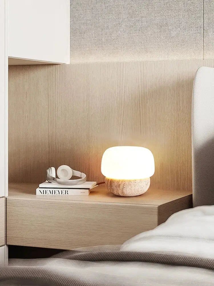 A warm cream mushroom table lamp with a smooth white glass top and textured stone base by decorbites