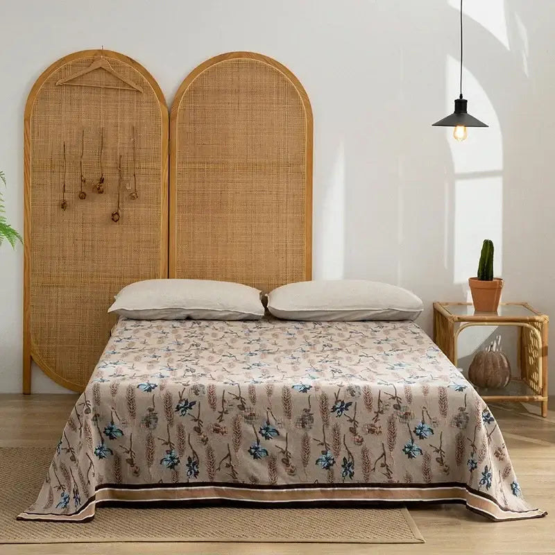 Beige decorbites cotton throw blanket with blue and brown floral pattern draped over a neatly made bed