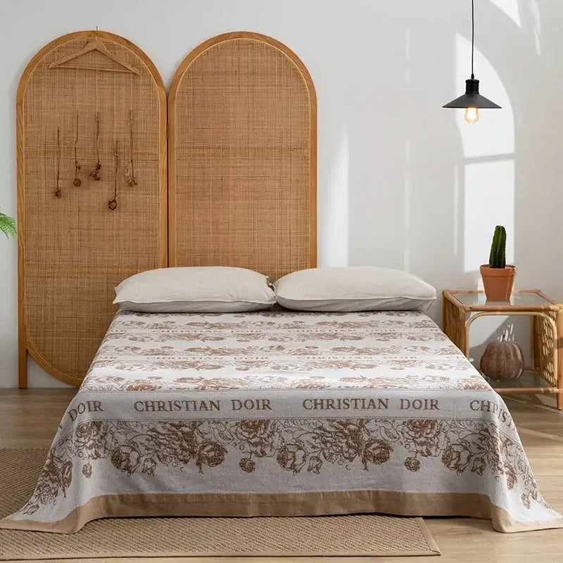 Beige and brown floral-patterned christian dior bedspread with woven rattan headboard and decorbites cotton throw blanket