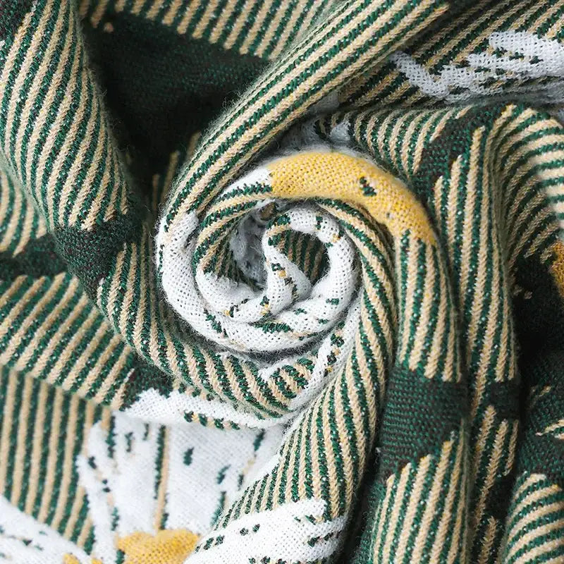 A cozy knitted decorbites cotton throw blanket with green and beige stripes and white yellow motifs for living room decor