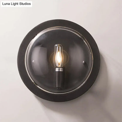 Retro dark gray metal wall sconce with clear glass shade and exposed filament bulb for living room lighting