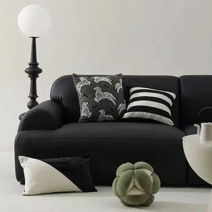 Black leather sofa with retro dark green zebra embroidered jacquard luxury pillow cover and plush cushion
