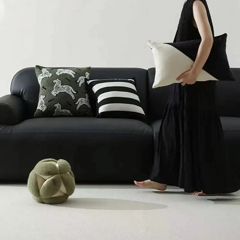 Olive green plush spherical ottoman with stitched geometric panels complementing luxury pillow embroidered jacquard design