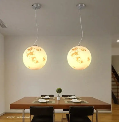 Two spherical warm glowing pendant lights with cratered moon surface in retro full moon chandelier for modern home