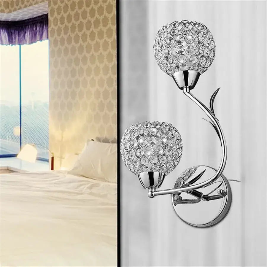 Chrome-finished crystal wall sconce with two spherical crystal globes on a curved vine-like arm for living room decorbites decor