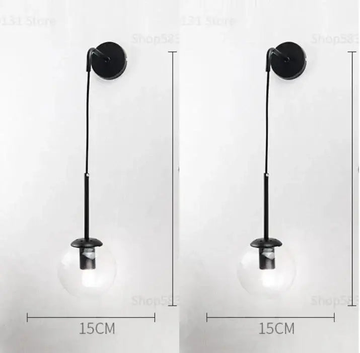 Black wall lamp with decorbites glass ball clear globe and slender metal stem for bedroom smoked sconce decor