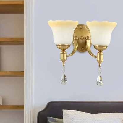 Gold-toned retro wall lamp with two blossom opaque glass shades and crystal teardrops for bedroom sconce lighting
