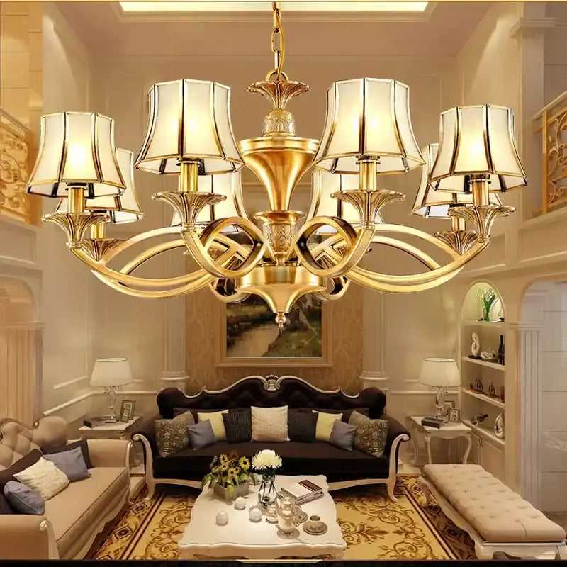 Gold-toned decorbites copper villa chandelier with ornate curved arms and cream lampshades for villa staircase decor