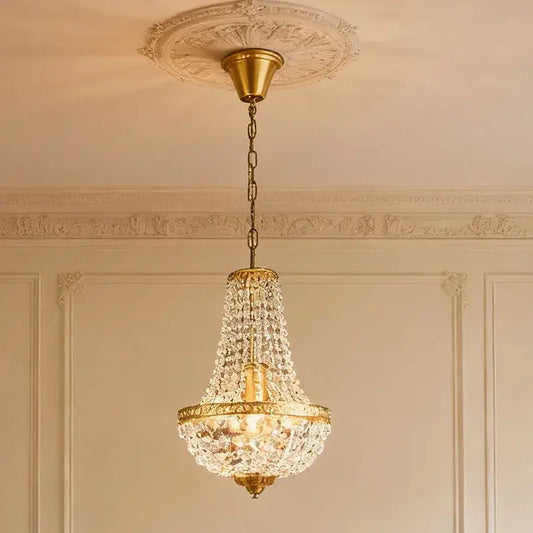 Retro golden crystal pendant light with cascading droplets and hanging chain for dining room decorative presence