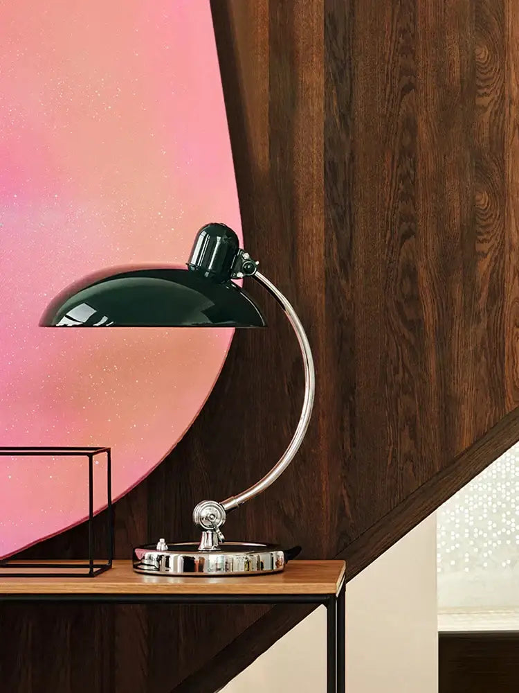 A sleek black metal table lamp with a curved chrome arm and adjustable head for focused lighting in office or bedroom
