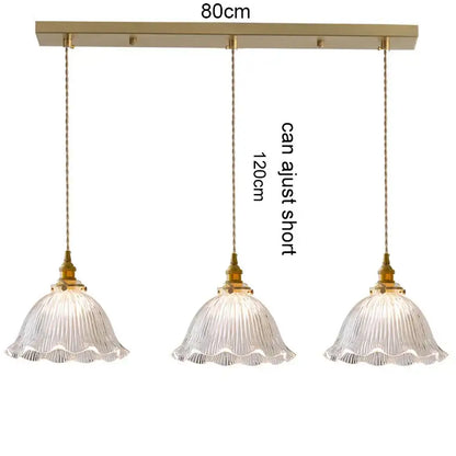 Gold-toned three-light pendant light with clear ribbed glass shades and wood accent for dining room with e27 led bulb compatibility