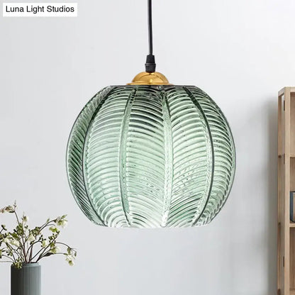 Retro green ribbed glass pumpkin dinette pendant lamp with translucent green glass and gold-toned fixture