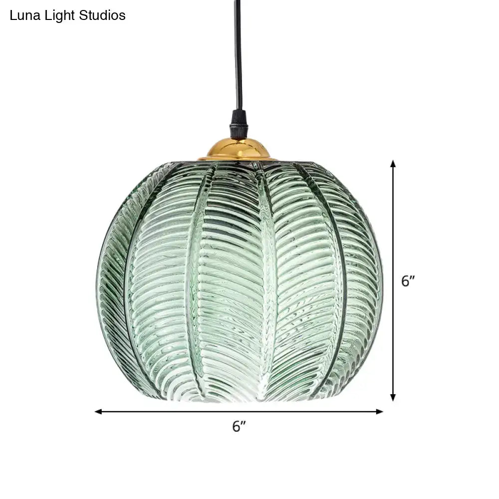 A 6-inch green glass pendant lamp with ribbed pumpkin design and brass top for retro dinette pendant lighting