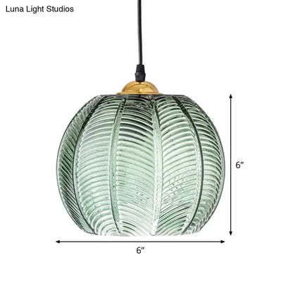 A 6-inch green glass pendant lamp with ribbed pumpkin design and brass top for retro dinette pendant lighting
