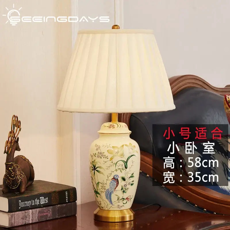 Cream-colored ceramic table lamp with hand-painted country flower bird motifs and gold-toned metal base for decorbites bedroom