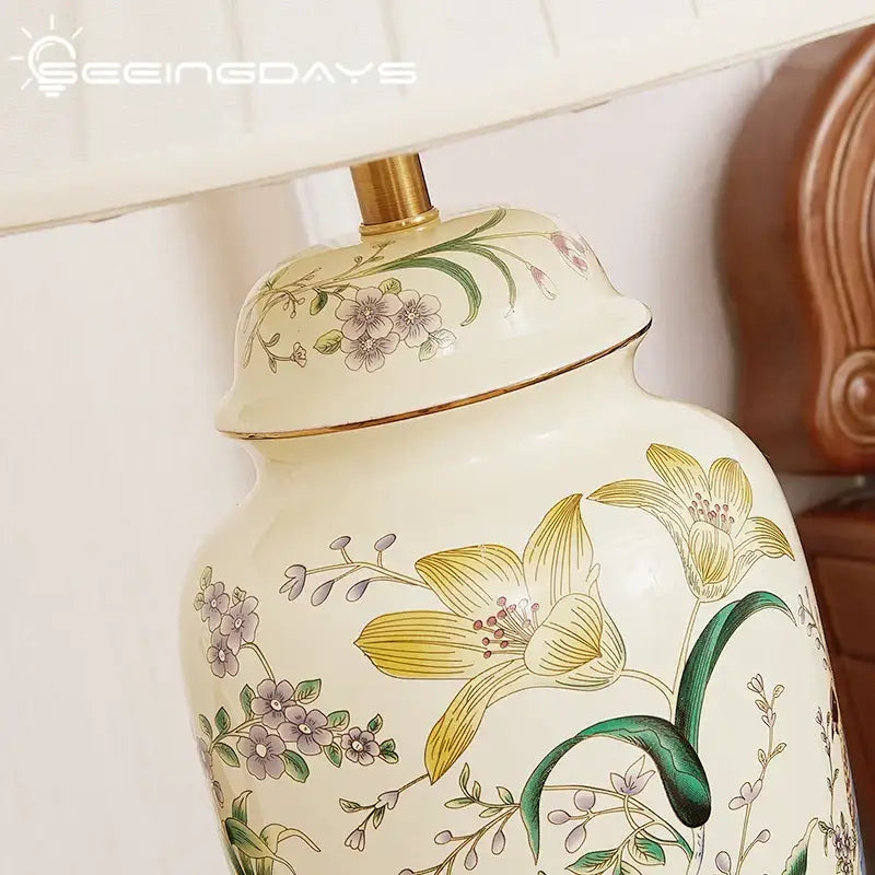 Cream-colored ceramic table lamp with hand-painted yellow lilies purple blossoms and green leaves decorbites country flower bird