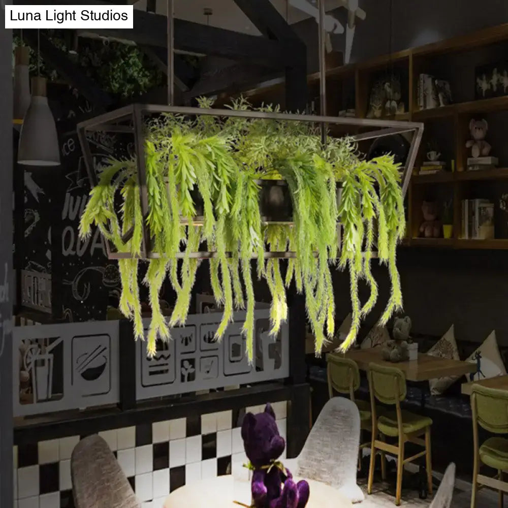 A hanging rectangular metal planter with cascading artificial greenery paired with a retro metal black LED ceiling light