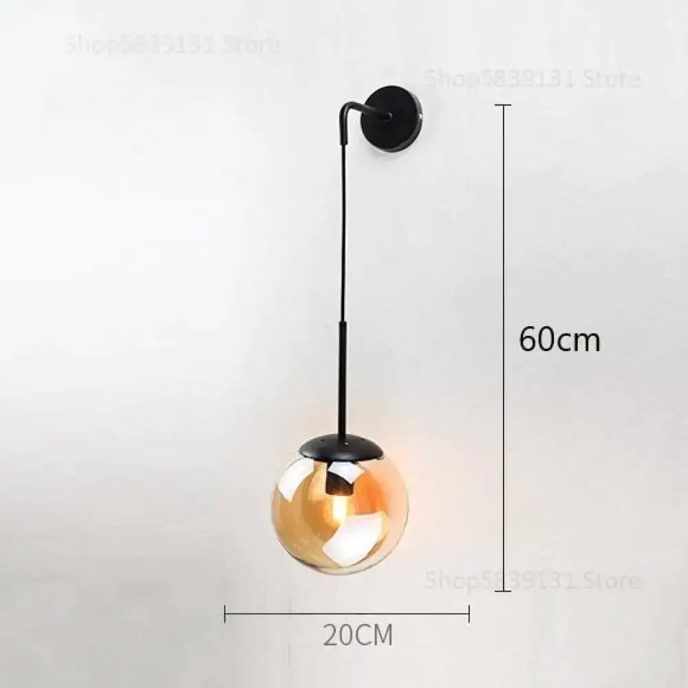 A sleek black metal wall lamp with a spherical amber retro modern glass globe for bedroom lighting