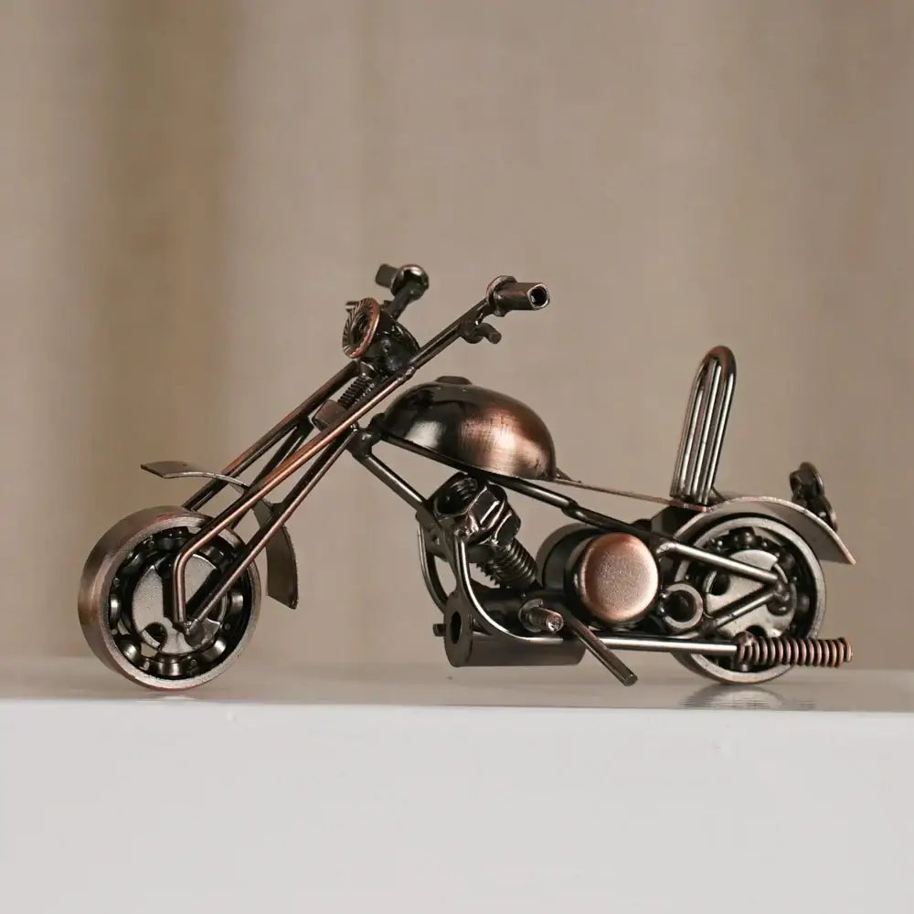 A rustic copper-toned metal figurine of a retro motorcycle model crafted from repurposed mechanical parts for decor
