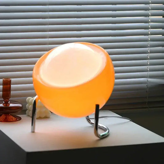Retro orange glass table lamp with glowing spherical glass shade and sleek chrome stand for bedroom night light decorbites glass table