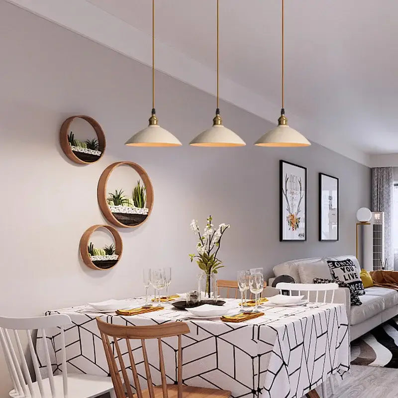 Three modern cream ceramic shades with gold-toned fixtures form a decorbites brass chandelier light for dining room decor