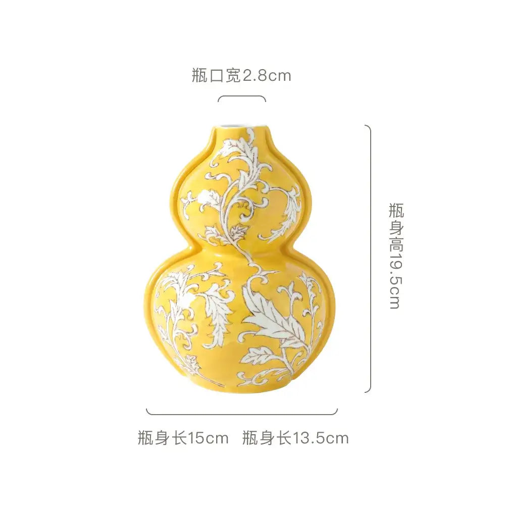 A vibrant yellow ceramic vase shaped like a traditional gourd with white floral patterns for living room decor