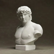 White marble bust of a muscular male figure with curly hair on a rectangular base by decorbites antinous retro plaster sculpture