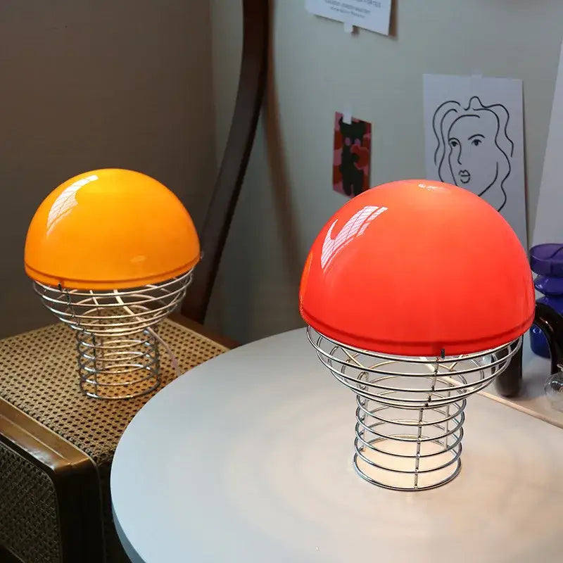 Retro red glass table lamp with vibrant orange and red mushroom caps and chrome wireframe base for bedroom use