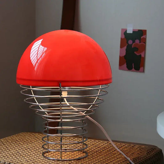 Retro red glass table lamp featuring a vibrant red dome shade and chrome wireframe base for bedroom use
