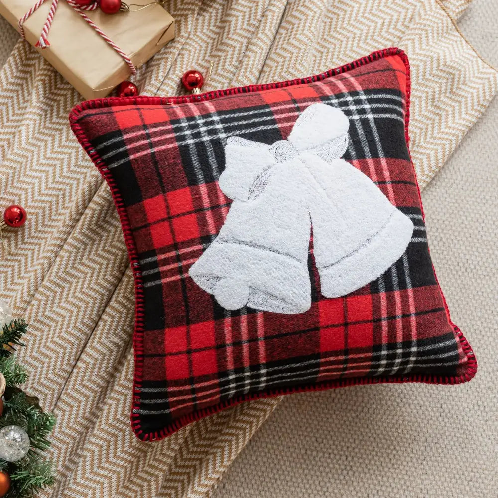 Red and black plaid pillow case with white embroidered bell design for retro snowflake jingle bell decor in living room
