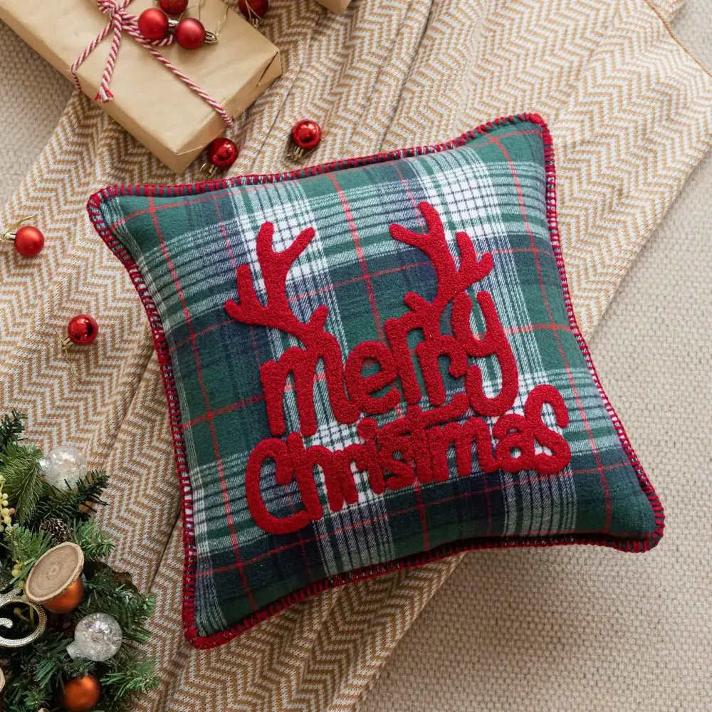 Festive green and red plaid pillow case with embroidered reindeer antlers and merry christmas text for living room