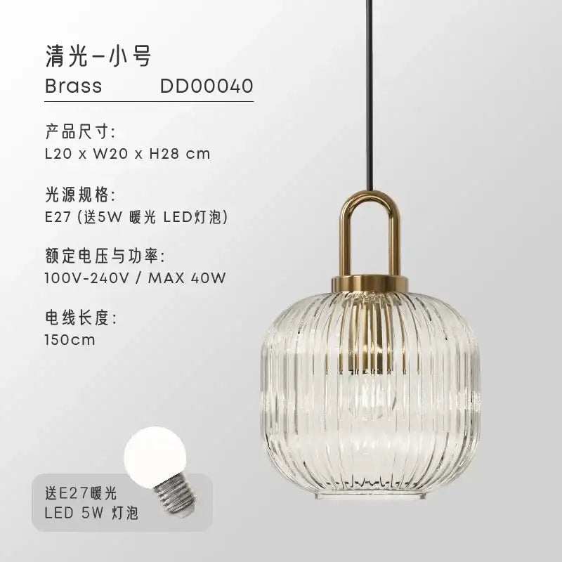 A modern brass-finished glass pendant light with a clear vertically ribbed globe and u-shaped hanging fixture for dining rooms