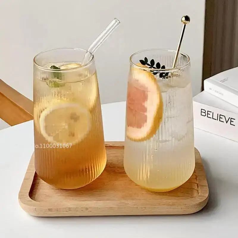 Two tall clear ribbed glass coffee cups with lemon and grapefruit slices and straws retro kitchen drinkware set