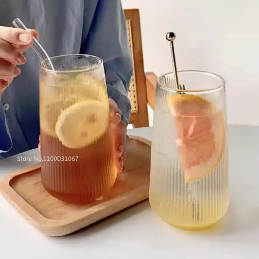 Two clear ribbed glass coffee cups with textured vertical lines and metallic stirrers in a retro design set