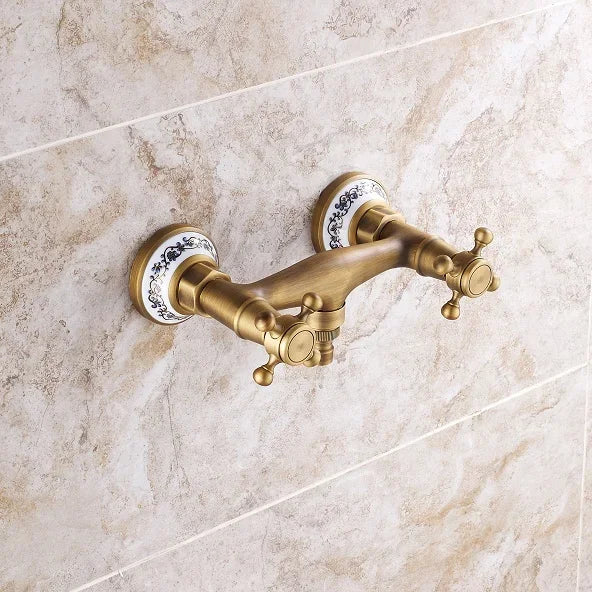 Antique brass double-handle bathroom faucet with porcelain escutcheons and blue floral patterns for retro showers