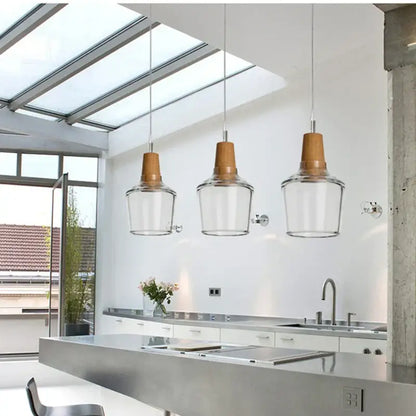Three warm-toned wooden top pendant lights with clear glass lampshades in a retro smoked glass lampshade pendant set