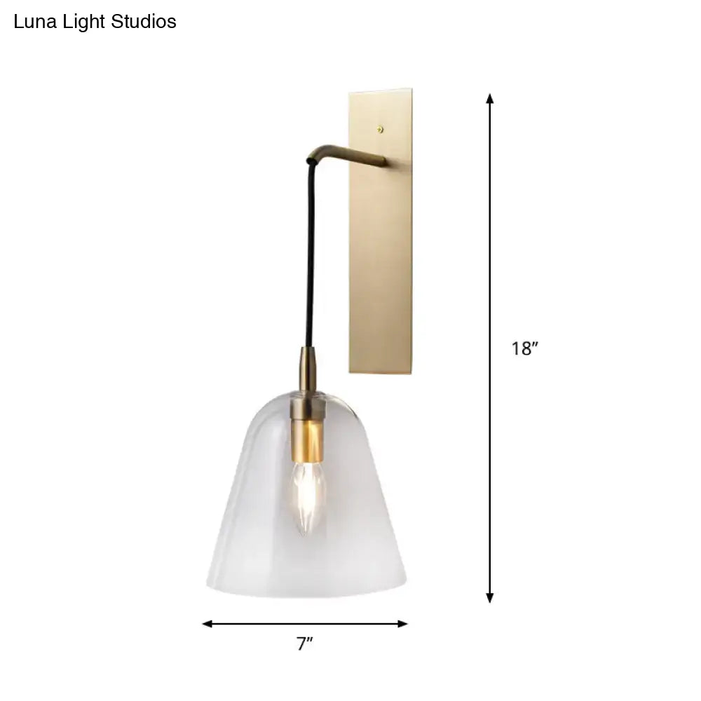 A retro style brass wall light with frosted glass bell-shaped shade and exposed e14 bulb base bedroom sconce